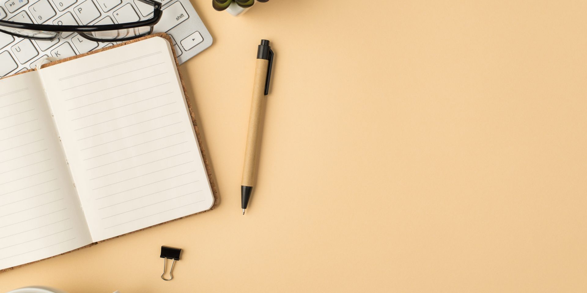 top-view-photo-glasses-white-keyboard-plant-organizer-pen-binders-cup-coffee-isolated-beige-background-with-copyspace (1) Differenza interpretariato e traduzione