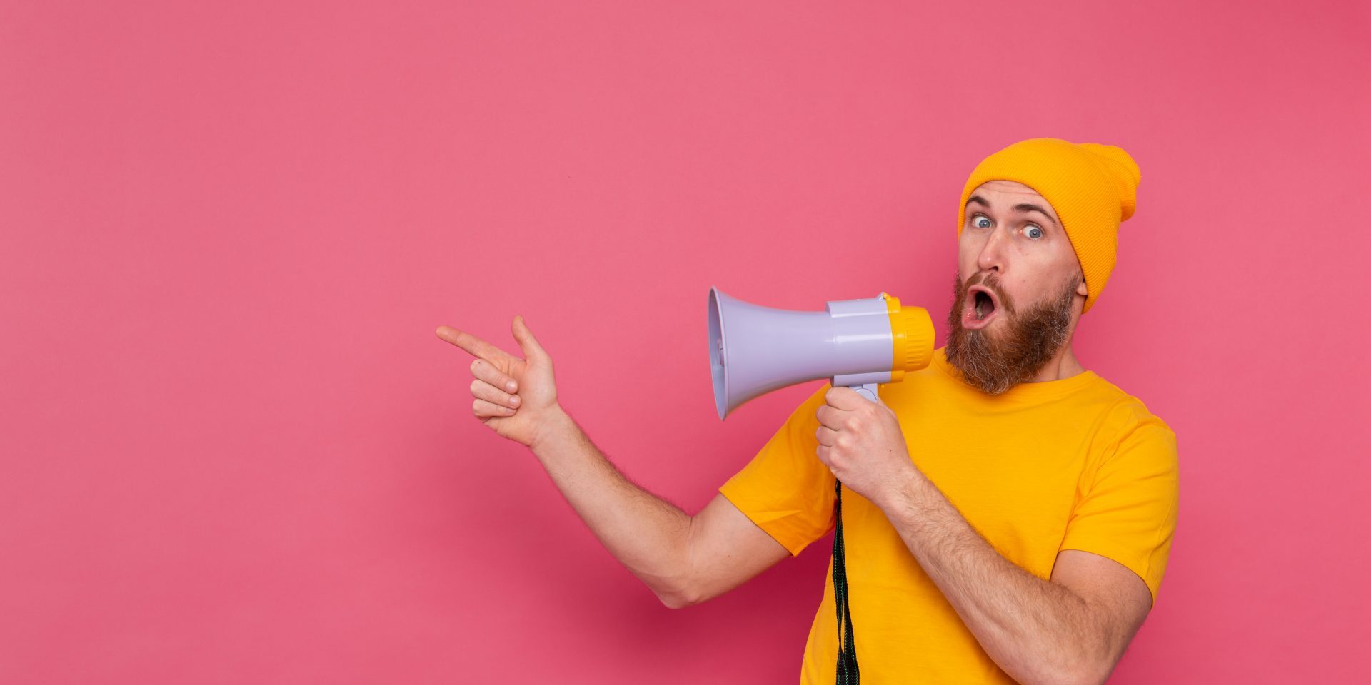 attention-european-man-with-megaphone-pointing-finger-left-pink-background call to action esempi